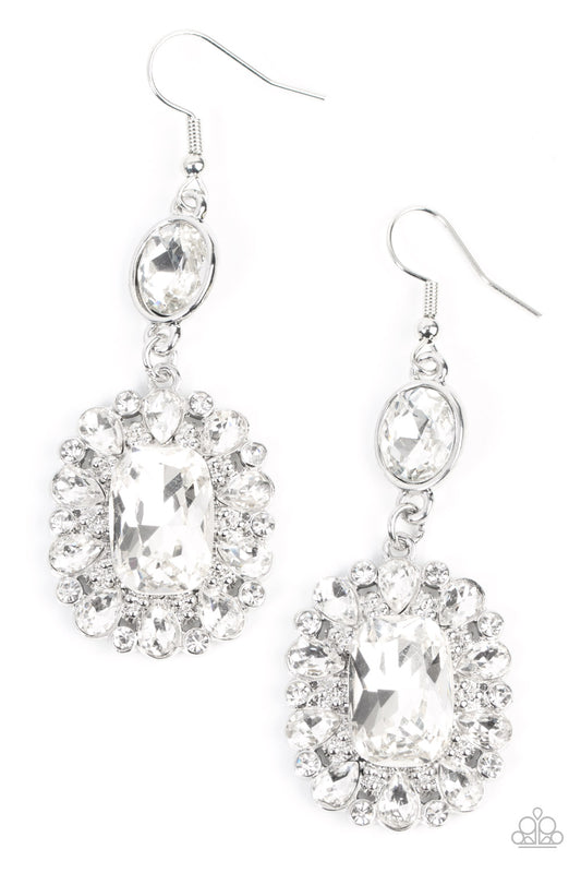 Dainty round and teardrop white rhinestones fan out from an oversized emerald cut gem at the bottom of a solitaire oval white rhinestone, resulting in a glamorously glitzy lure. Earring attaches to a standard fishhook fitting.  Sold as one pair of earrings.
