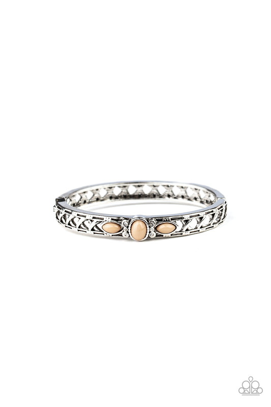 Dotted with a Lark beaded and glassy rhinestones encrusted centerpiece, a crisscrossing silver bangle-like cuff slides along the wrist for a whimsical look. Features a hinged closure.  Sold as one individual bracelet.