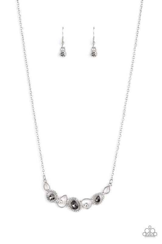 An incandescent assortment of shiny silver frames, dainty white rhinestones, and oversized smoky gems delicately coalesce into a statement-making sparkle below the collar. Features an adjustable clasp closure.  Sold as one individual necklace. Includes one pair of matching earrings.