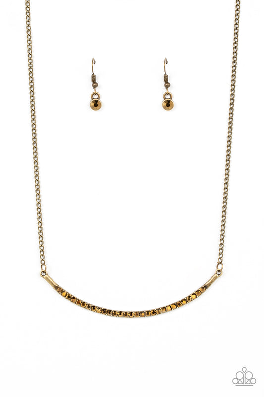 Encrusted in glitzy aurum rhinestones, a curved brass bar bows below the collar for a smoldering style. Features an adjustable clasp closure.  Sold as one individual necklace. Includes one pair of matching earrings.