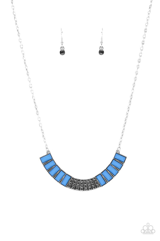 Stacked rows of hematite rhinestones and faceted emerald cut French Blue beads coalesce into a colorful half moon pendant, creating a refreshing pop of color below the collar. Features an adjustable clasp closure.  Sold as one individual necklace. Includes one pair of matching earrings.