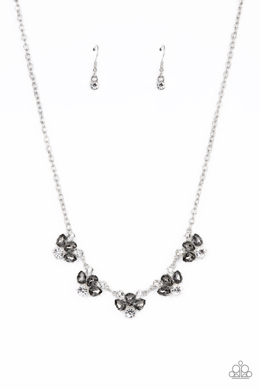 Featuring round and teardrop cuts, white and smoky rhinestones delicately link into a sparkling statement piece that results into an envious glow below the collar. Features an adjustable clasp closure.  Sold as one individual necklace. Includes one pair of matching earrings.