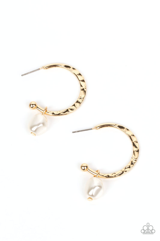 An imperfect white pearl glides along a hammered gold hoop, creating a timeless twist. Earring attaches to a standard post fitting. Hoop measures approximately 1" in diameter.  Sold as one pair of hoop earrings.
