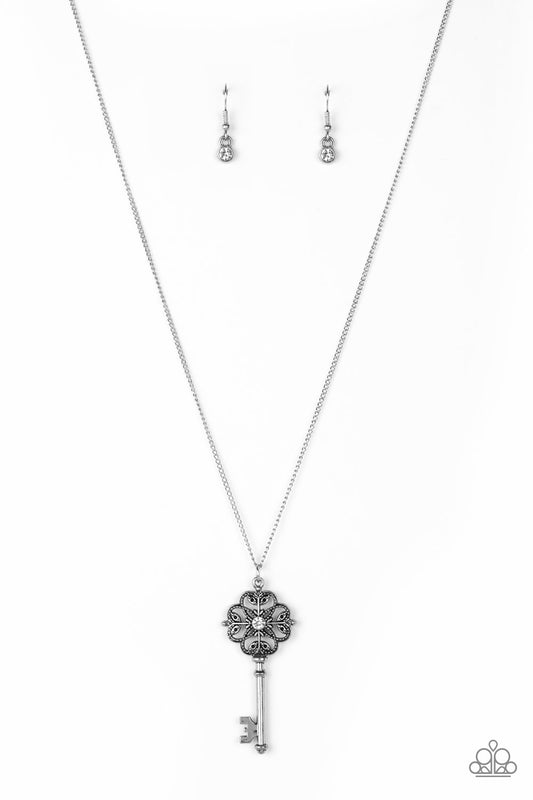 Dotted with a glittery white rhinestone, a vintage inspired key pendant swings from the bottom of an elegantly elongated silver chain for a whimsical look. Features an adjustable clasp closure.  Sold as one individual necklace. Includes one pair of matching earrings.