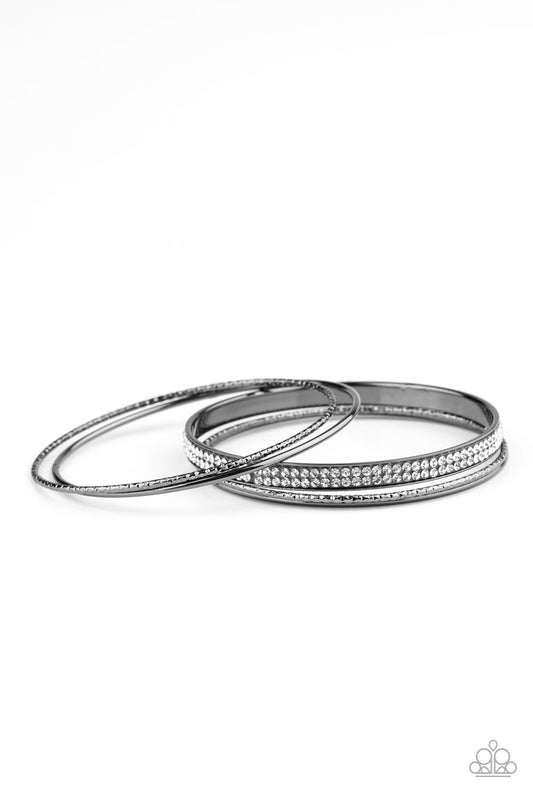 Pairs of smooth and hammered gunmetal bangles join a white rhinestone encrusted bracelet around the wrist, creating an edgy stack of sparkle.  Sold as one set of five bracelets.