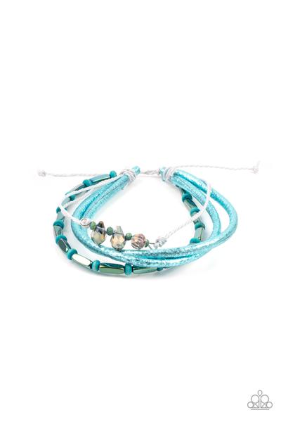 A mismatched collection of metallic beads, blue wooden beads, and iridescent crystal-like beads are threaded along gray threaded and glittery blue leather cording, creating stellar layers around the wrist. Features an adjustable sliding knot closure.  Sold as one individual bracelet.