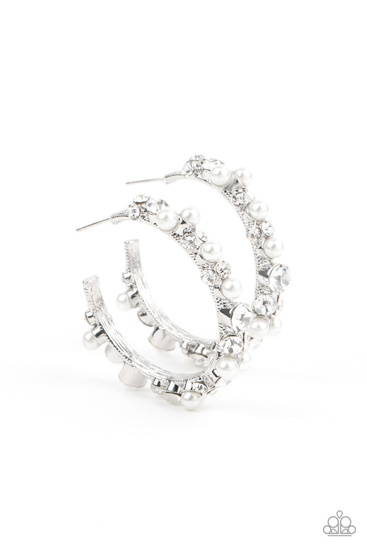 A bubbly array of classic white rhinestones and glassy white rhinestones are encrusted along the front of a silver hoop, creating an elegantly effervescent look. Earring attaches to a standard post fitting. Hoop measures approximately 1 1/2" in diameter.  Sold as one pair of hoop earrings.
