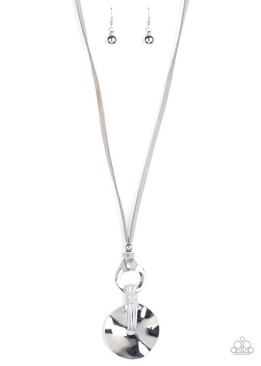 A hammered silver disc is knotted in place at the bottom of a hammered silver ring, creating a rustic pendant at the bottom of a skinny piece of gray leather. Features an adjustable sliding knot closure.  Sold as one individual necklace. Includes one pair of matching earrings.