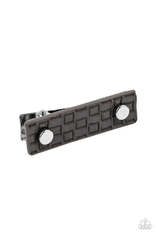 Dotted with two silver studs, a piece of gray leather that is embossed in an edgy geometric pattern adorns the front of a rectangular silver frame, creating a retro display. Features a standard hair clip on the back.  Sold as one individual hair clip.