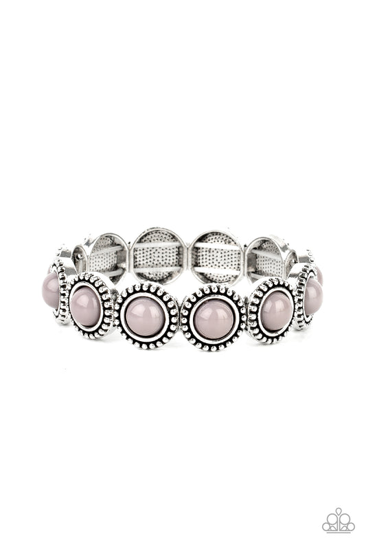 Featuring an antiqued silver studded edge, silver frames encase polished gray beads. The eye-catching series of fanciful beads are threaded along a stretchy band and promenade around the wrist for a whimsical look.

Sold as one individual bracelet.
