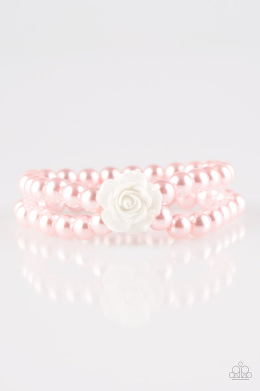 Connected by a flirty white resin rose, classic pink pearls are threaded along stretchy bands around the wrist for a vintage inspired fashion.

Sold as one individual bracelet.