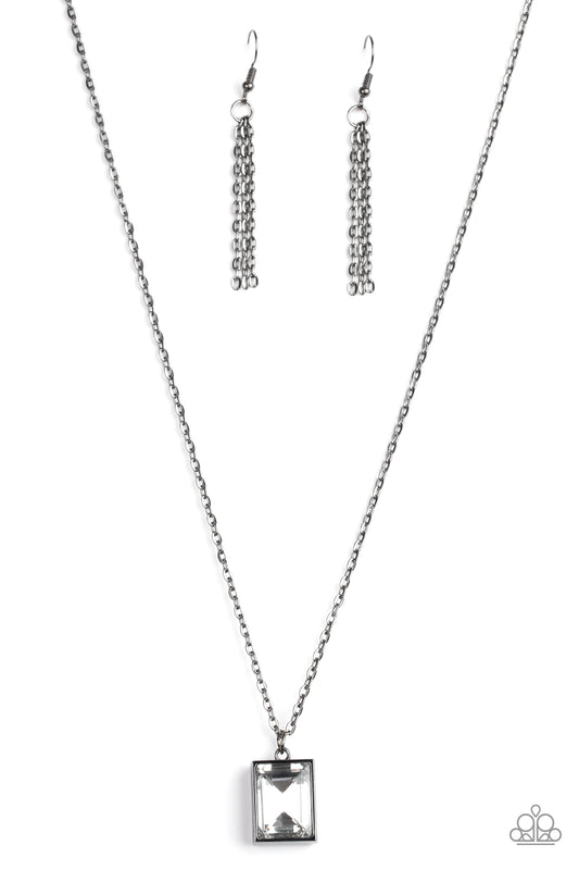 Featuring an emerald style cut, a faceted white gem is pressed into a sleek gunmetal frame at the bottom of a dainty gunmetal chain below the collar for an edgy look. Features an adjustable clasp closure.  Sold as one individual necklace. Includes one pair of silver fringe earrings.
