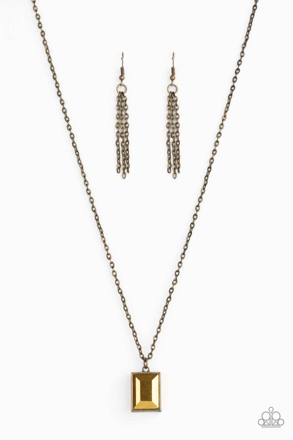 Featuring an emerald style cut, a faceted aurum gem is pressed into a sleek brass frame at the bottom of a dainty brass chain below the collar for an edgy look. Features an adjustable clasp closure.  Sold as one individual necklace. Includes one pair of brass fringe earrings.