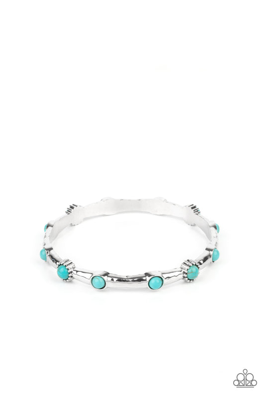 Dotted with dainty turquoise stones, a hammered silver bangle glides along the wrist for a colorfully earthy look.  Sold as one individual bracelet.