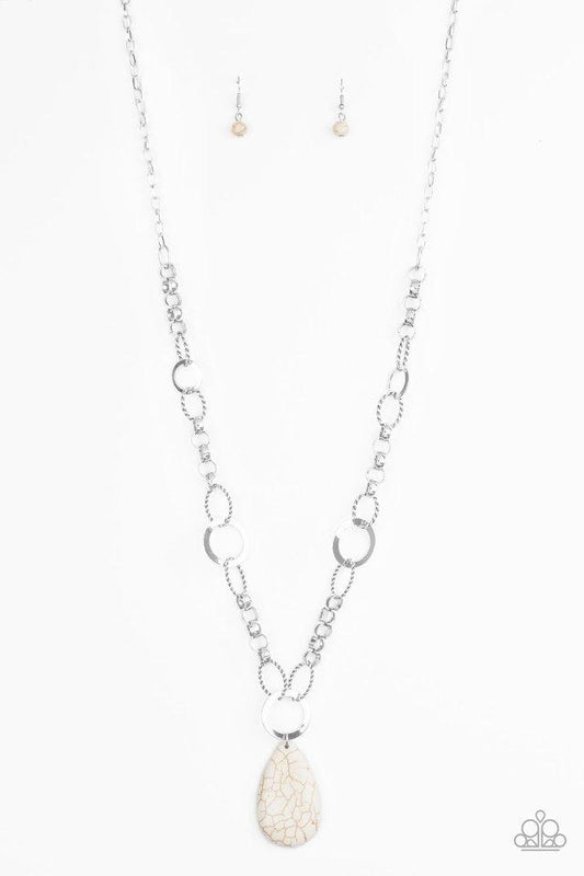 A mismatched collection of bold silver links, textured silver ovals, and flat silver rings connect down the chest, creating a unique chain. Chiseled into a tranquil teardrop, a refreshing white stone pendant swings from the bottom of the metallic compilation for an earthy finish. Features an adjustable clasp closure.  Sold as one individual necklace. Includes one pair of matching earrings.