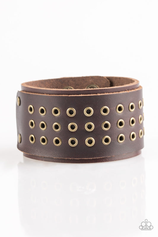 Rows of brass frames are pressed into a piece of leather. The leather piece is studded across the front of a thick leather band for a rugged urban look. Features an adjustable snap closure.  Sold as one individual bracelet.