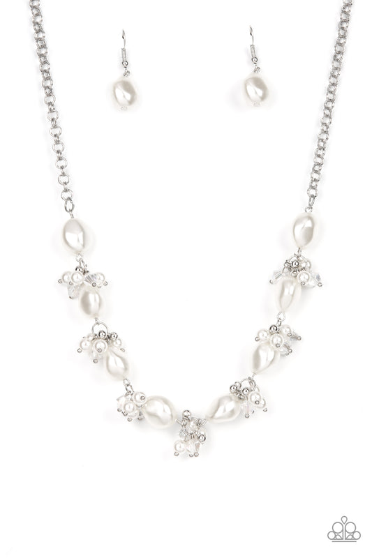 Imperfect white pearls alternate with clusters of iridescent crystals and white pearls below the collar, creating an effervescently elegant display. Features an adjustable clasp closure.  Sold as one individual necklace. Includes one pair of matching earrings.