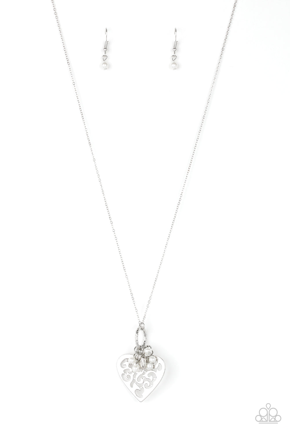 Infused with dainty white pearls and a shimmery silver heart charm, a stenciled silver heart pendant swings from the bottom of a lengthened silver chain for a whimsical look. Features an adjustable clasp closure.  Sold as one individual necklace. Includes one pair of matching earrings.