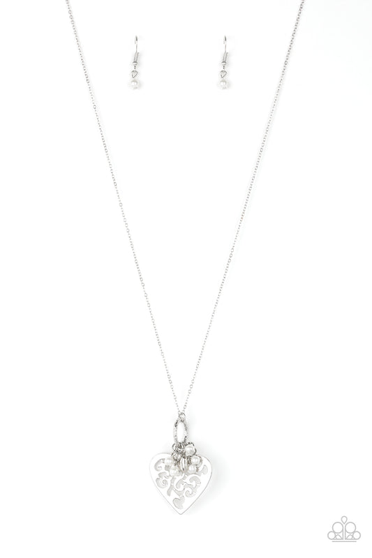 Infused with dainty white pearls and a shimmery silver heart charm, a stenciled silver heart pendant swings from the bottom of a lengthened silver chain for a whimsical look. Features an adjustable clasp closure.  Sold as one individual necklace. Includes one pair of matching earrings.