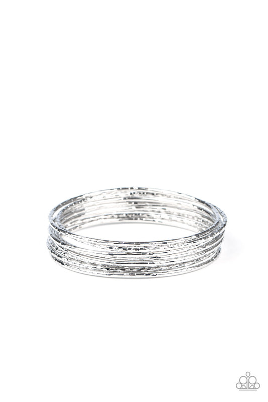 Etched and hammered in shimmery details, a stack of glistening silver bangles stack across the wrist for a flawless finish.  Sold as one set of eight bracelets.