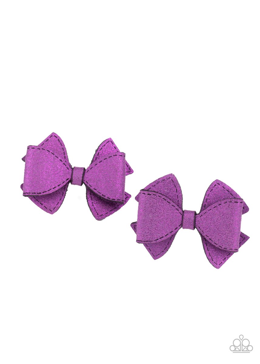 Dusted in purple glitter, two purple suede ribbons delicately knot into a pair of colorful hair bows. Each bow features a standard hair clip on the back.  Sold as one pair of hair clips.
