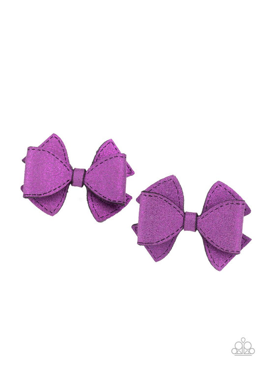 Dusted in purple glitter, two purple suede ribbons delicately knot into a pair of colorful hair bows. Each bow features a standard hair clip on the back.  Sold as one pair of hair clips.