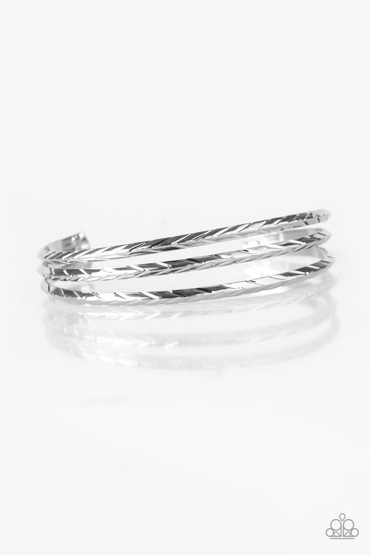 Etched in shimmery geometric patterns, glistening silver bars arc across the wrist, coalescing into a dainty cuff.  Sold as one individual bracelet.
