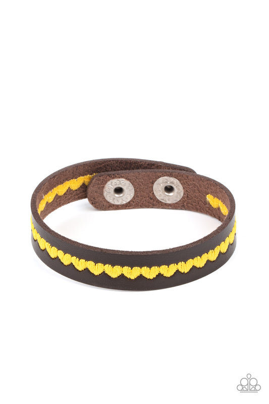 Featuring the sunny hue of Illuminating, a colorful row of yellow hearts is stitched across the front of a dainty brown leather band. Features an adjustable snap closure.  Sold as one individual bracelet.