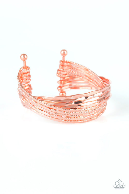 Attached to two shiny copper rods, shimmery and hammered shiny copper bars crisscross across the wrist, coalescing into a stacked cuff.  Sold as one individual bracelet.