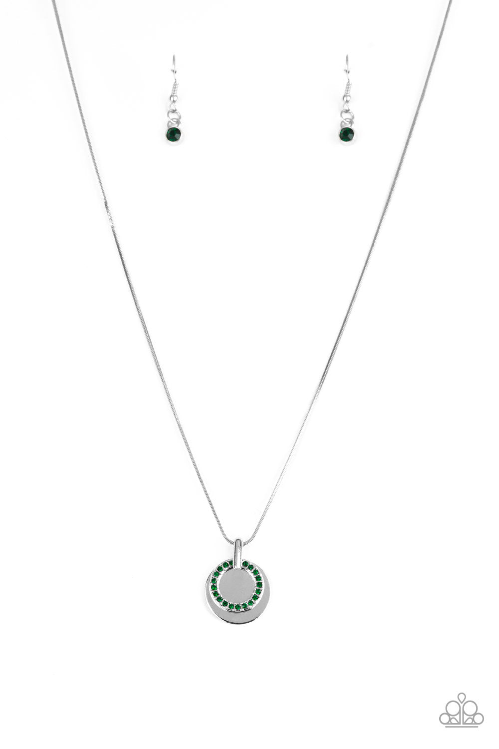 A glistening silver disc and a green rhinestone encrusted ring slide along a sleek silver chain, coalescing into a refined pendant below the collar. Features an adjustable clasp closure.  Sold as one individual necklace. Includes one pair of matching earrings.