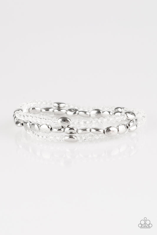 Infused with hints of silver, dainty white crystal-like beads are threaded along stretchy bands, creating whimsical layers across the wrist.

Sold as one set of three bracelets.