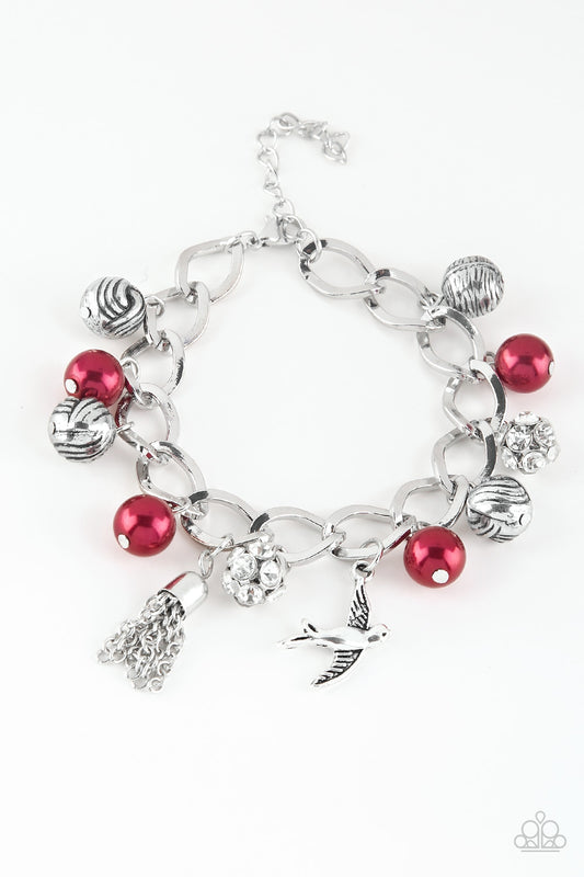 Red pearls, ornate silver beads, and white rhinestone encrusted accents swing from a dramatic silver chain. A shimmery silver bird charm and silver tassel are added to the display, creating a whimsical fringe around the wrist. Features an adjustable clasp closure.

Sold as one individual bracelet.