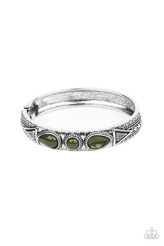 Studded in tribal inspired designs, the top of an antiqued silver cuff-like bangle is embellished with shiny Military Olive beads for a colorful look. Features a hinged closure.  Sold as one individual bracelet.