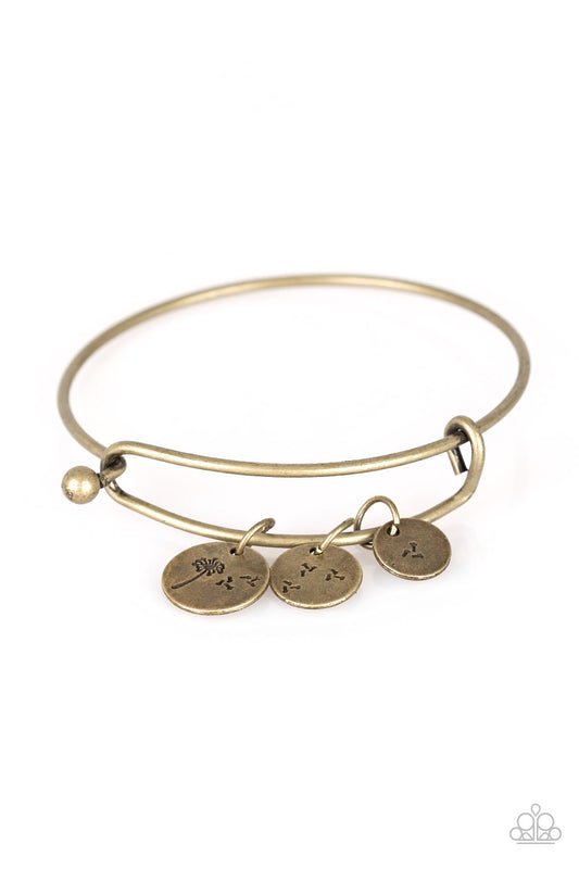 Stamped in dandelion patterns, glistening brass charms featuring floral patterns slide along a sleek bar fitting for a whimsical look. Features a toggle closure.  Sold as one individual bracelet.