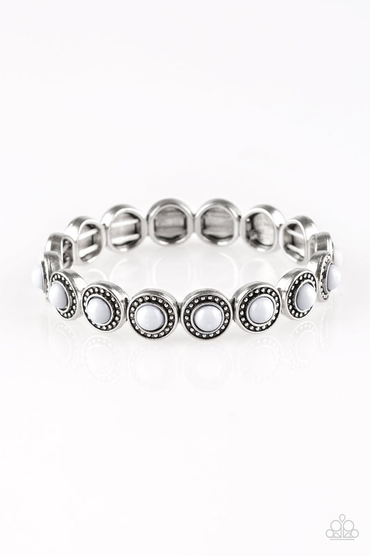 Dotted with neutral gray beaded centers, studded silver frames are threaded along stretchy elastic bands and linked around the wrist for a whimsical look.  Sold as one individual bracelet.