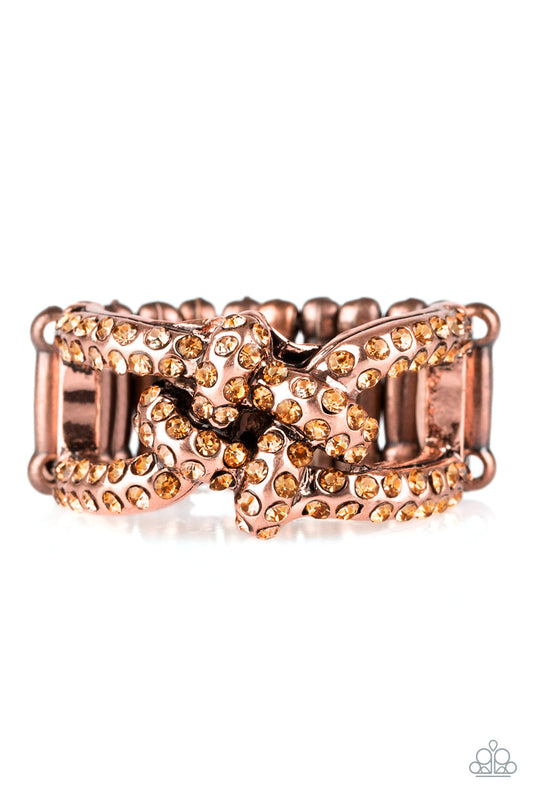 Encrusted in glittery rhinestones, shimmery copper bars crisscross across the finger, coalescing into a bold square knot atop the finger. Features a stretchy band for a flexible fit. Sold as one individual ring.