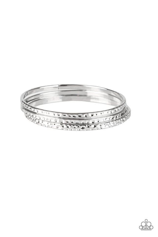 Delicately hammered in shimmery textures, a trio of glistening silver bangles glide across the wrist for a sleek look.  Sold as one set of three bracelets.