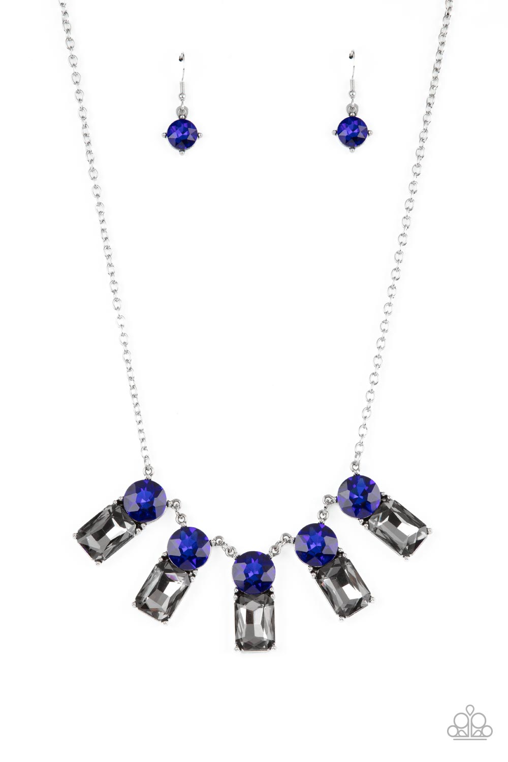 A sparkly row of oversized blue gems regally sit atop emerald cut smoky rhinestone bases as they delicately link along a dainty silver chain below the collar, resulting in a royal glamorous centerpiece. Features an adjustable clasp closure.  Sold as one individual necklace. Includes one pair of matching earrings.