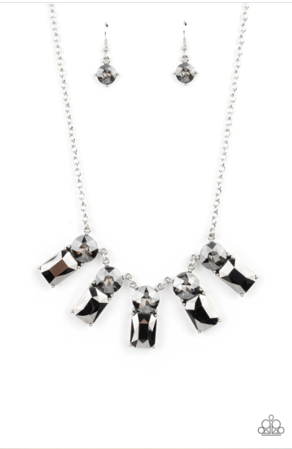 Featuring classic pronged fittings, a dramatic collection of oversized smoky rhinestones and emerald cut hematite gems fan out below the collar for an outrageous sparkle. Features an adjustable clasp closure.  Sold as one individual necklace. Includes one pair of matching earrings.