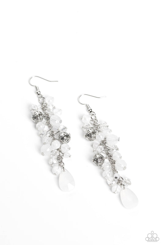 A dainty collection of white teardrop and round beads, textured silver accents, and faceted white crystal-like beads trickle from a single strand of silver chain, resulting in a cheekily clustered chandelier. Earring attaches to a standard fishhook fitting.  Sold as one pair of earrings.