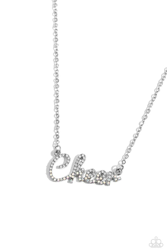 Curled in a script font, glistening silver letters spell out the word "Cheer" along a dainty silver chain. Embossed on the letters, dainty white rhinestones and iridescent rhinestones create a subtle ombré effect for a peppy finish. Features an adjustable clasp closure. Due to its prismatic palette, color may vary.  Sold as one individual necklace. Includes one pair of matching earrings.