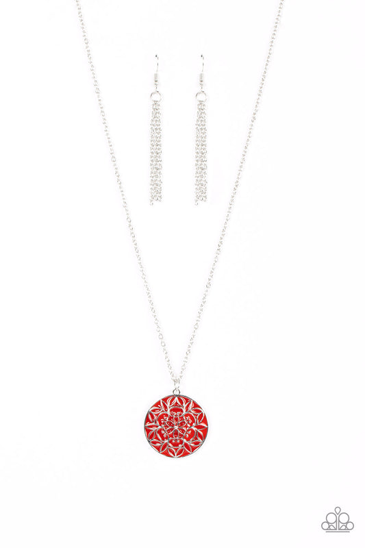 A mandala-like floral motif is embossed across the front of a shiny red frame, resulting in a whimsical pendant at the bottom of a dainty silver chain. Features an adjustable clasp closure.  Sold as one individual necklace. Includes one pair of matching earrings.