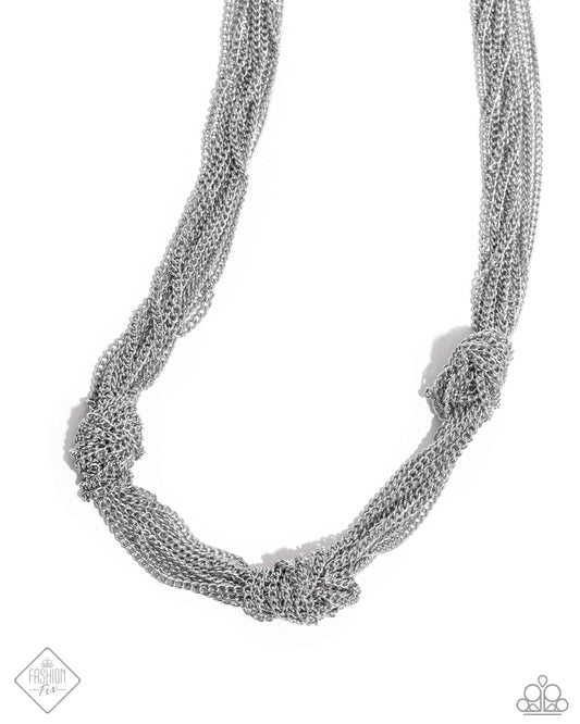 Featuring a high-sheen, strand after strand of classic silver chains cascade below the neckline, knotting along the center of the display in three separate places for a subtly industrial statement. Features an adjustable clasp closure.  Sold as one individual necklace. Includes one pair of matching earrings.