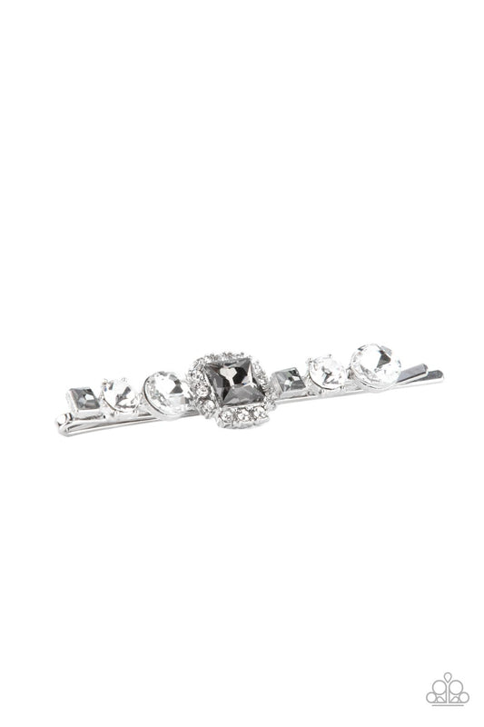 Varying in shape and size, a mismatched collection of white round and smoky square rhinestones adorn the front of a classic silver bobby pin. An elegant centerpiece adorns the center, tying the timeless look together.  Sold as one individual decorative bobby pin.