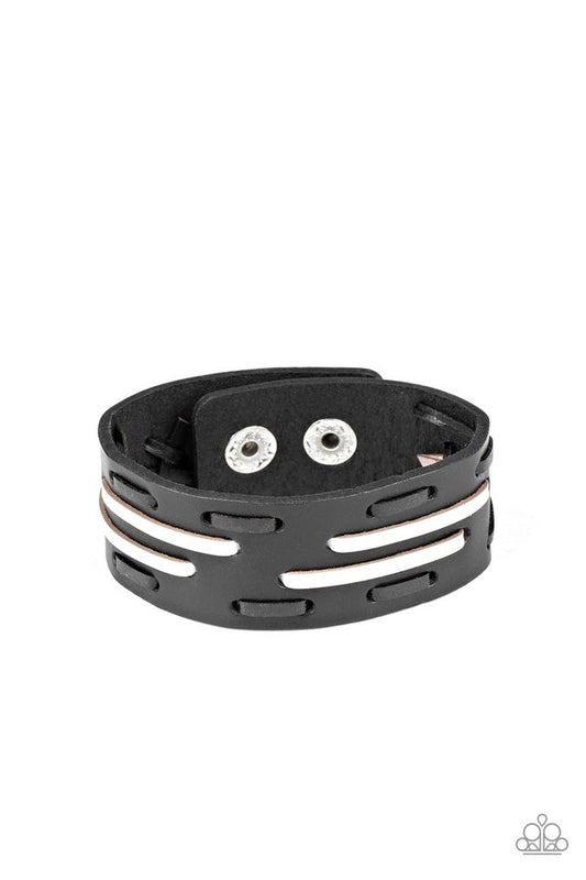 Black and white leather laces are haphazardly threaded through a thick black leather band, creating a rustic display around the wrist. Features an adjustable snap closure.  Sold as one individual bracelet.