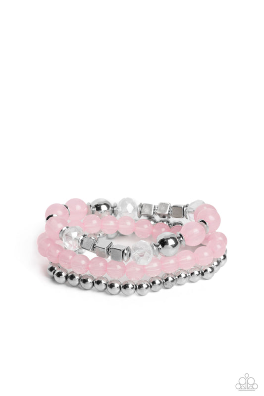 Varying in shape and size, shiny silver beads, silver cube beads, silver accents, baby pink opaque beads, and reflective crystal-like beads are threaded along elastic stretchy bands, creating colorful layers across the wrist.  Sold as one set of three bracelets.