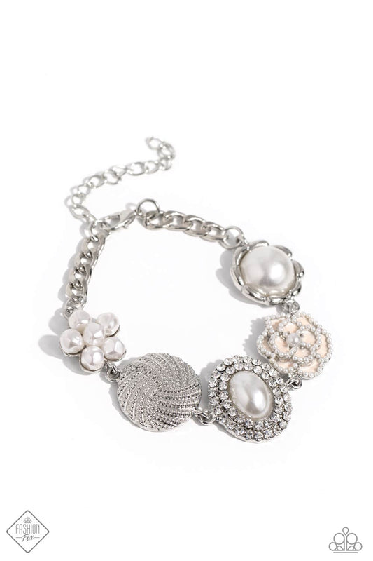 A refined display of shimmery pearl charms and floral-inspired accents gather along the wrist creating a cultivated display. The hodgepodge of texture and sheen includes pearl-adorned flowers in various shapes, borders of white rhinestones around an oval pearl center, and tactile silver studs emanating in a twisted pattern. Features an adjustable clasp closure.  Sold as one individual bracelet.