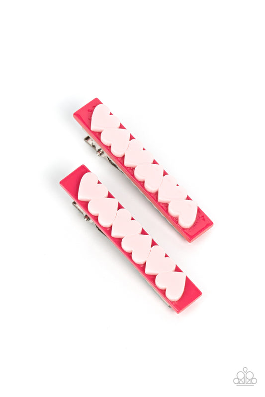 A row of light pink hearts alternate across the front of a darker pink rectangular frame, creating a charming pair of flirtatious hair clips. Features standard hair clips on the back.  Sold as one pair of hair clips.