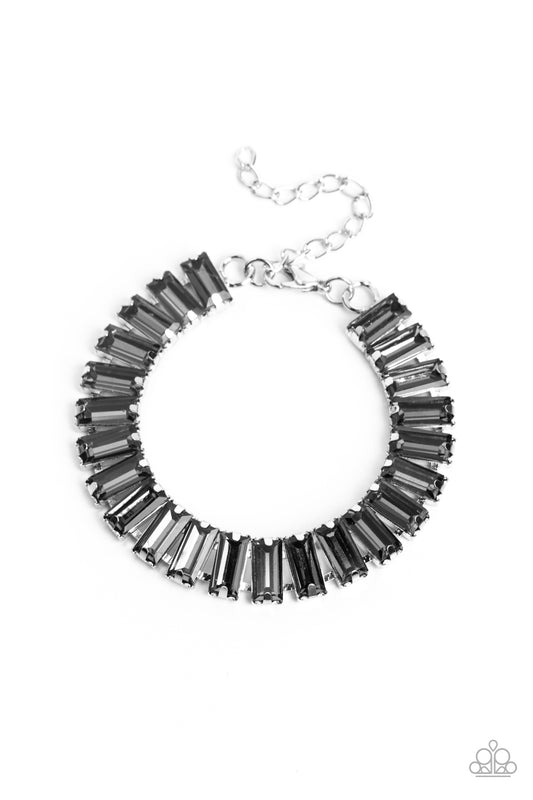 Set in prominent, pronged silver fittings, a glassy collection of emerald-cut, smoky gems fall in line around the wrist, creating a stunning, light-catching display. Features an adjustable clasp closure.  Sold as one individual bracelet.