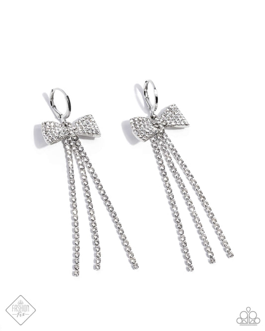 Featuring silver square fittings, high-sheen strands of sparkling white rhinestones cascade from a stunning white rhinestone-embellished bow charm, creating a classy statement at the ear. The stunning bow charm swings along a silver hinge hoop, further displaying shimmer and glam. Earring attaches to a standard hinge closure fitting. Hoop measures approximately 3/4" in diameter.  Sold as one pair of hinge hoop earrings.